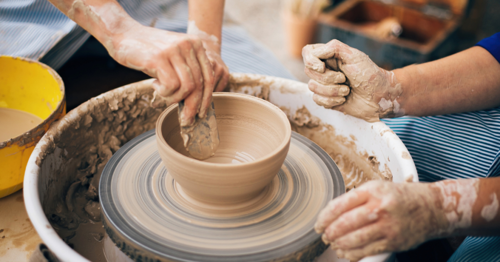 Hands shaping clay on a pottery wheel, representing a creative hobby.