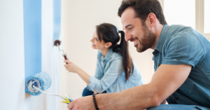 A couple painting a wall together during a DIY home project.