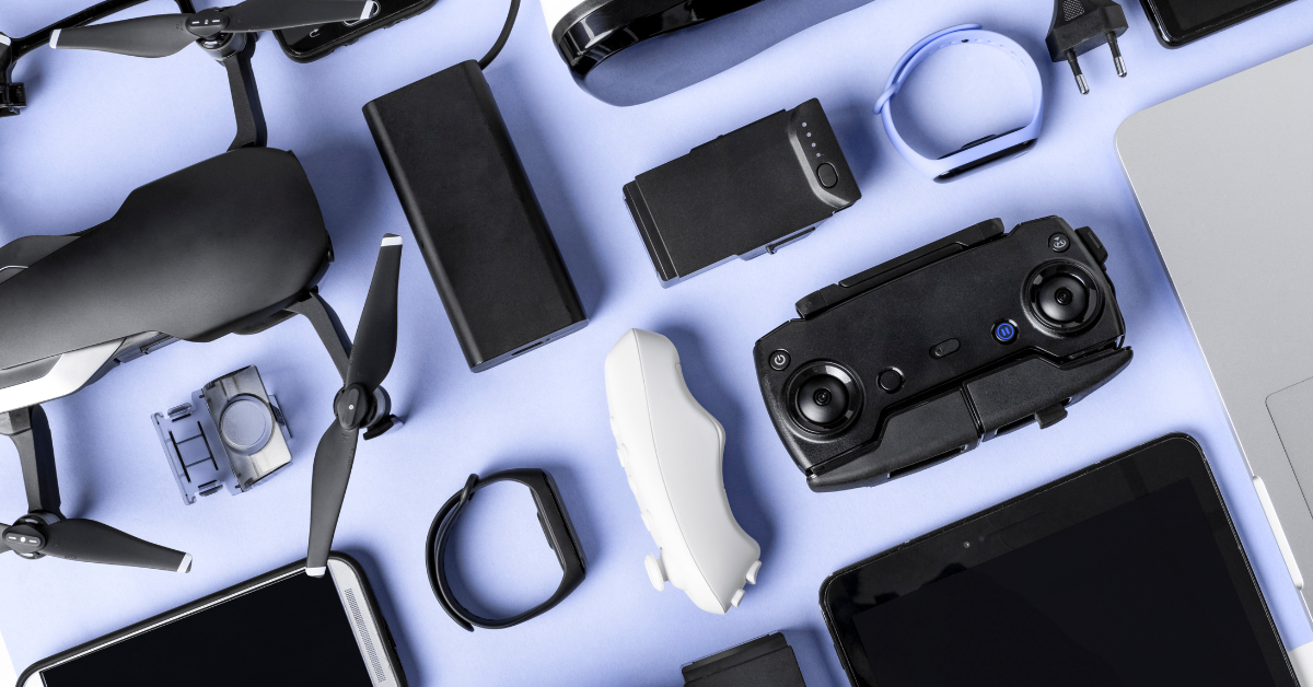 Flat lay of various tech gadgets and devices on a light blue background.